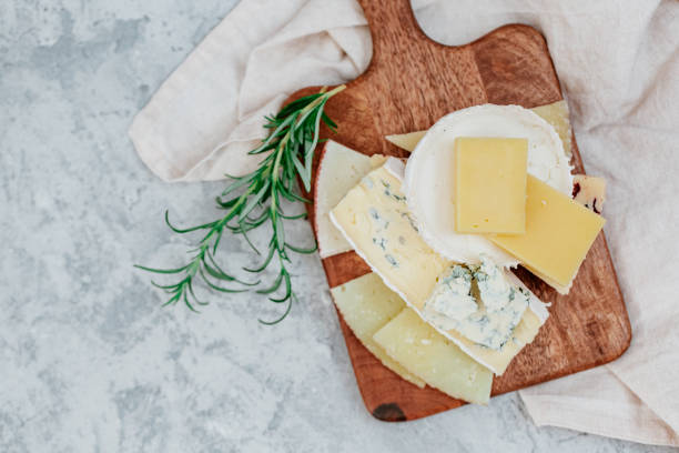 istock Wooden board with different kinds of delicious cheese on table 1214581408