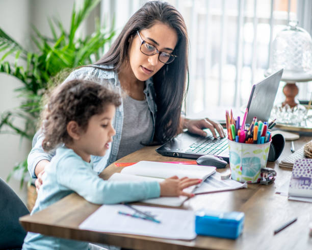 istock Mother and daughter working from home. 1214587159