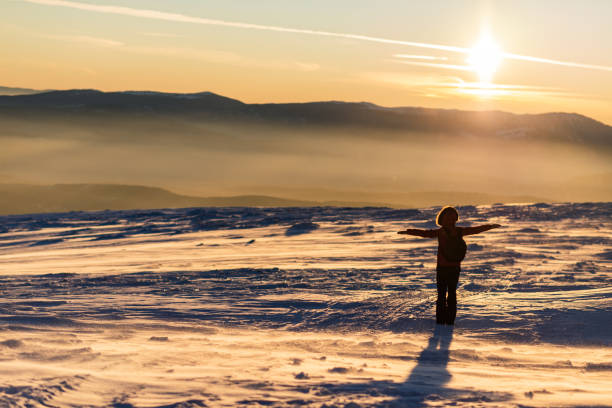 Adult woman meditating on the top of the mountain.