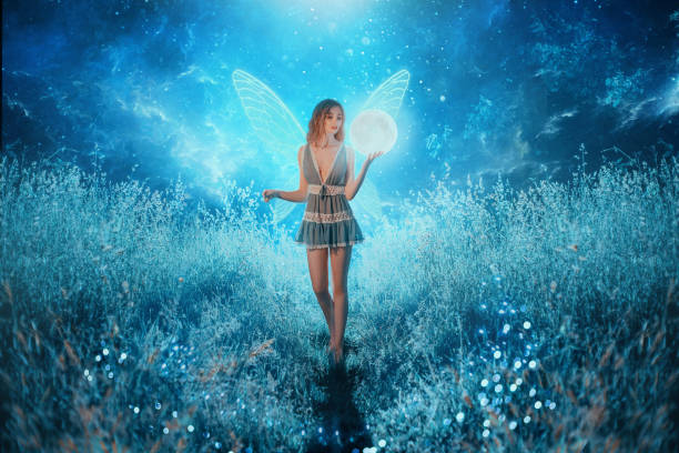 Fairy tale elf holds in hands luminous planet universe cosmos bright stars moon. Girl in blue short sexy dress transparent wings. Long red hair. Backdrop magic forest trees grass fireflies space glow elfo de cuento de hadas sostiene en manos luminoso planeta universo estrellas brillantes luna. chica en azul corto sexy vestido transparente alas. pelo largo y rojo. telón de fondo mágico bosque árboles hierba luciérnagas espacio brillan