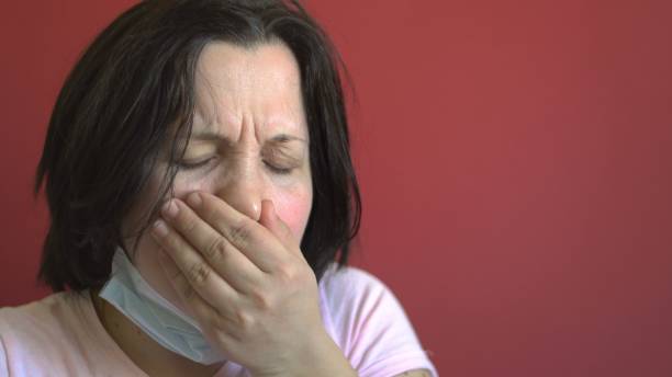 istock Sick woman coughing. Red background 1214590084