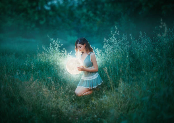 red haired witch. woman in blue green mint color short sexy dress, holds glow shining moon globe lamp. Casual fashion wear. Elf princess. Power of nature miracle. bright summer forest. Ball gold light bruja pelirroja. mujer en azul verde menta color corto sexy vestido, sostiene brillante lámpara de globo lunar brillante. ropa de moda casual. princesa elfo. milagro del poder de la naturaleza. bosque de verano brillante. luz de oro de bola