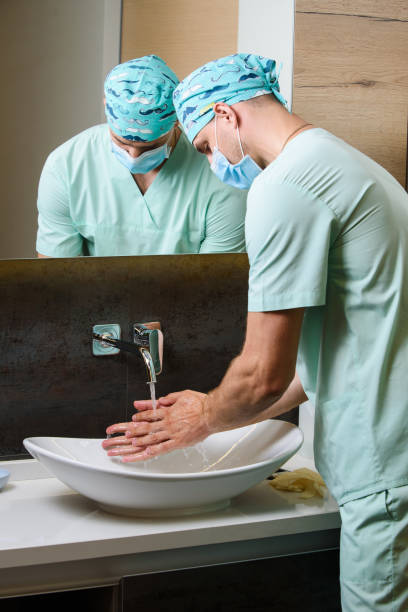 istock Medical student surgeon cleans his hands with antiseptic. wash hands with soap often under water to stop pandemic of coronavirus covid 19 1214592012