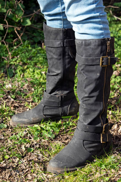 istock Black boots and jeans on lawn 1214592660