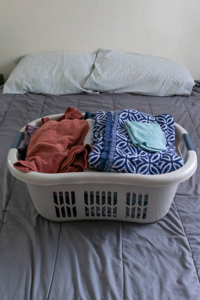 istock Freshly laundered clothes neatly in a laundry basket waiting to be folded on a bed. 1214596651