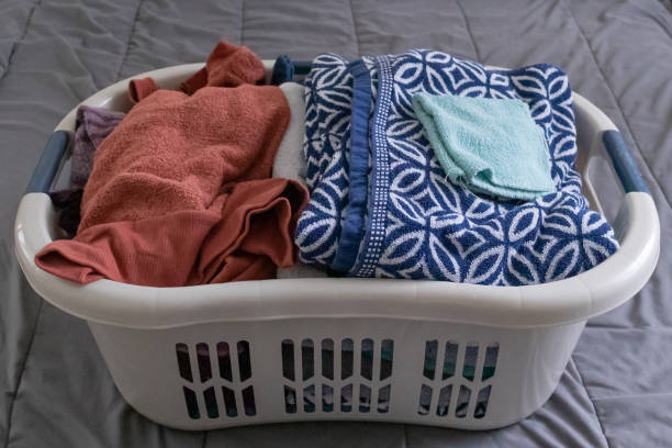 istock Freshly laundered clothes neatly in a laundry basket waiting to be folded on a bed. 1214596652