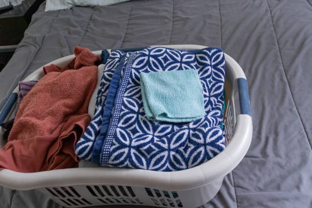 istock Freshly laundered clothes neatly in a laundry basket waiting to be folded on a bed. 1214596653