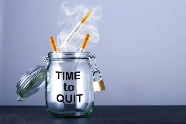 Photo of Cigarettes and text: Time to Quit on gray background with copy space.