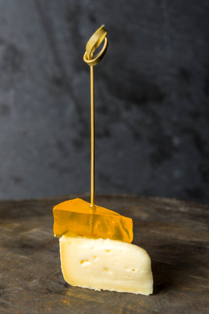 istock tasty canapes with cheese on a small skewer on a gray background. Vertical frame 1214603508