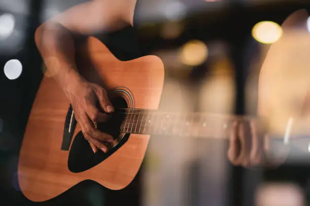 Close up guy's hand playing guitar.