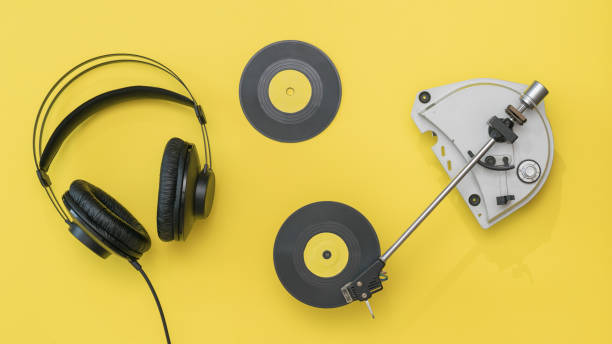 istock Two yellow vinyl discs, headphones and a player on a yellow background. 1214607442