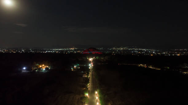 pyramid of the sun in Teotihuacan at night during a night show with the full moon in the background stock photo