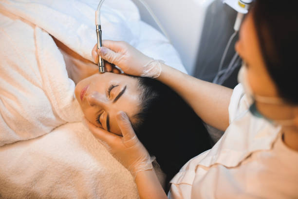 Charming caucasian brunette is having a facial spa procedure while lying with closed eyes Charming caucasian brunette is having a facial spa procedure while lying with closed eyes microdermabrasion stock pictures, royalty-free photos & images