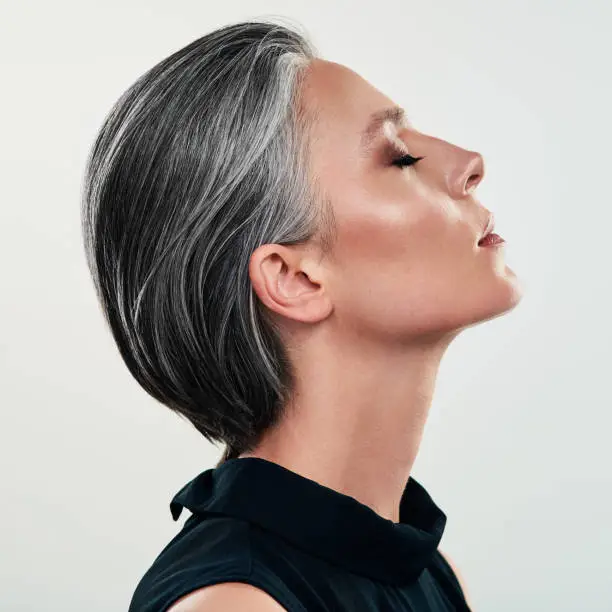 Studio shot of a beautiful mature woman posing against a grey background