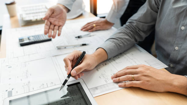 istock Real-estate concept, Two engineer and architect discussing blueprints data working and digital tablet on construction building project 1214621001
