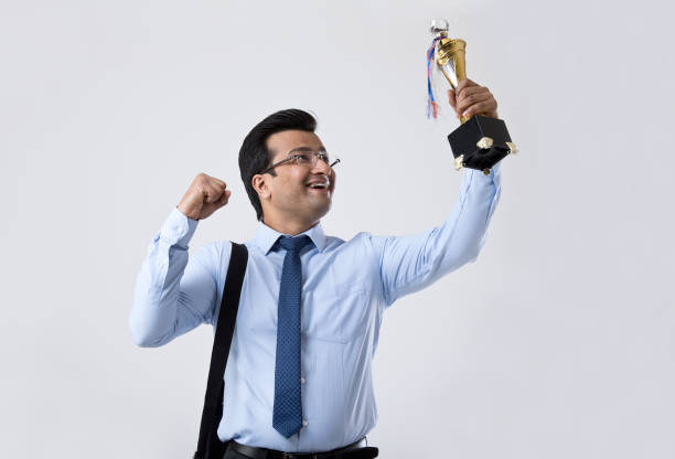 istock Successful businessman holding a trophy 1214621635