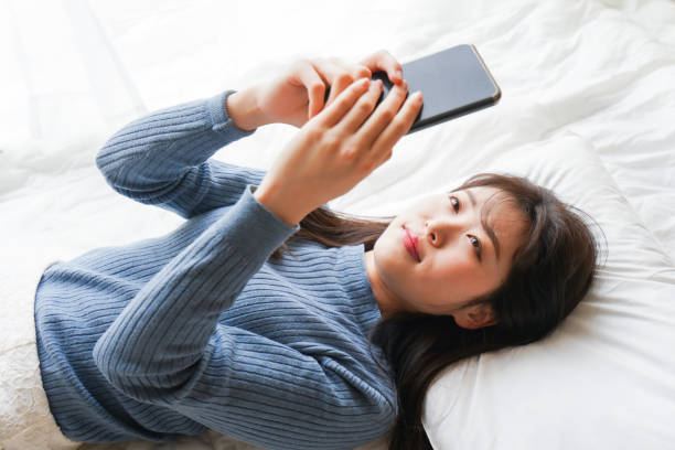 istock Young woman use the smartphone before going to sleep in bed 1214621645