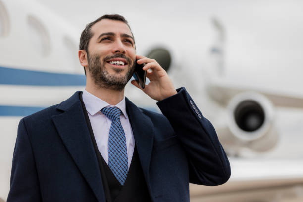 istock Businessman talking on phone in front of executive jet 1214624102