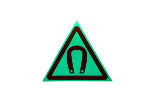 warning sign magnet in a green triangle on a white background concept