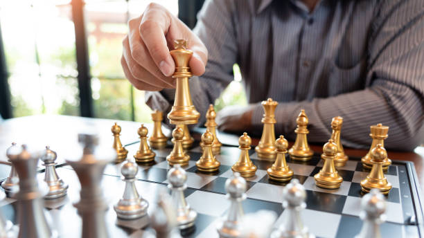 istock Business man take a king figure checkmate on the chess board game - strategy, management or leadership success concept 1214628453
