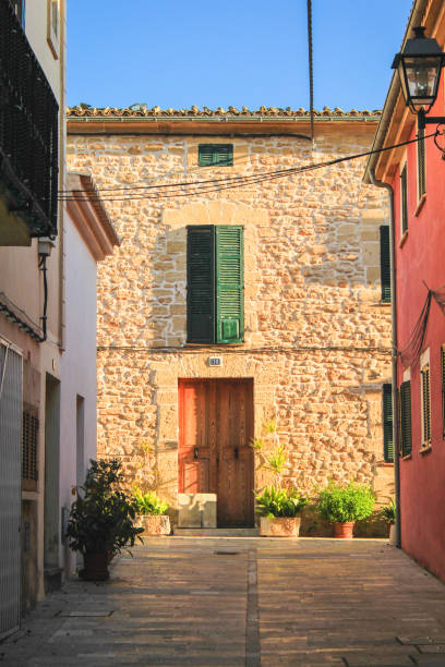 Street lantern and open window shutters in the afternoon siesta. 