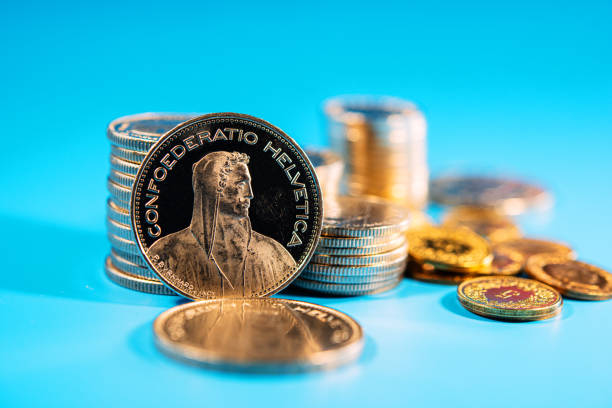 five franc Swiss coin amid stacks of coins. five franc Swiss coin amid stacks of coins. Web banner. swiss coin stock pictures, royalty-free photos & images