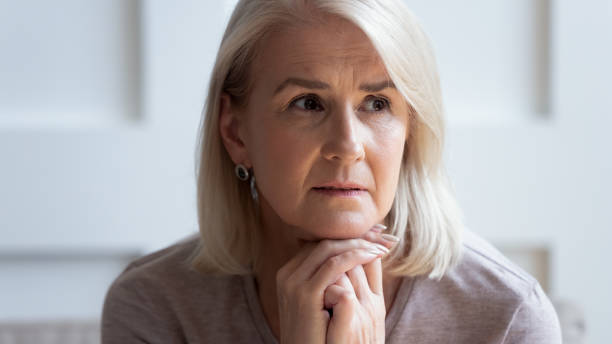 istock Head shot unhappy upset older woman thinking about problems 1214631421