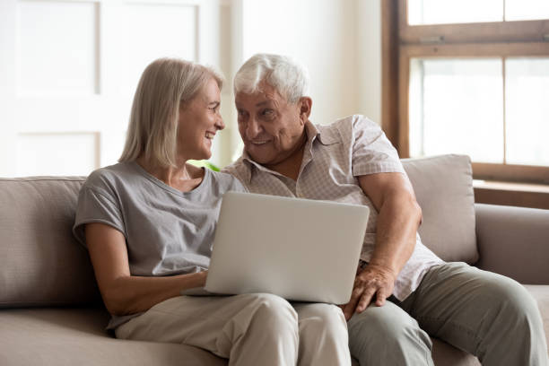 istock Happy older wife and husband using laptop together, having fun 1214631500