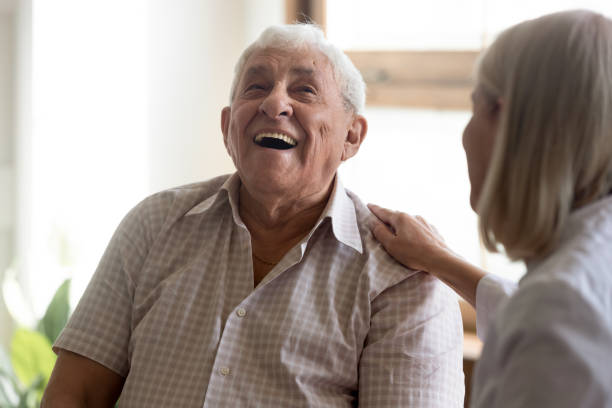 excited older man patient laughing, having fun with caregiver - aging process middle women men imagens e fotografias de stock
