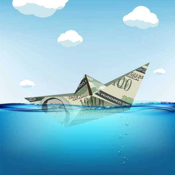 istock Paper boat made from dollar currency sinking in water 1214631573