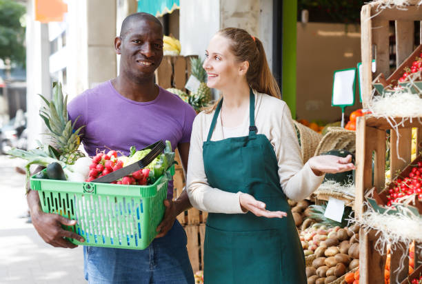 istock Nice seller helping client choose fruits 1214631685