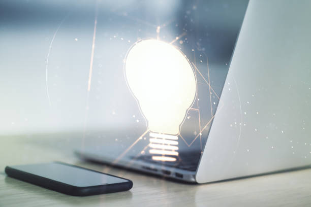 istock Double exposure of creative light bulb hologram on laptop background, research and development concept 1214633488
