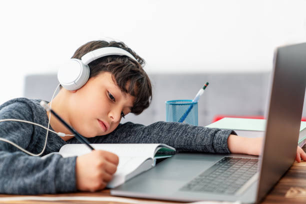 istock Little boy is studying in front of the laptop. E learning, study at home online. 1214633791