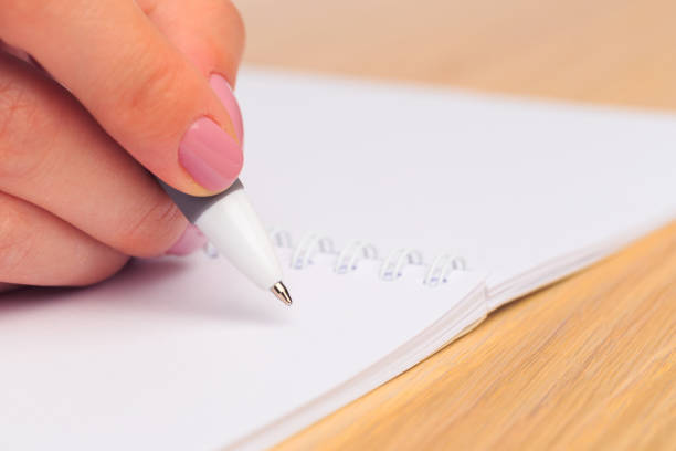 istock female hands write in a notebook . Office place . Close up view 1214634535