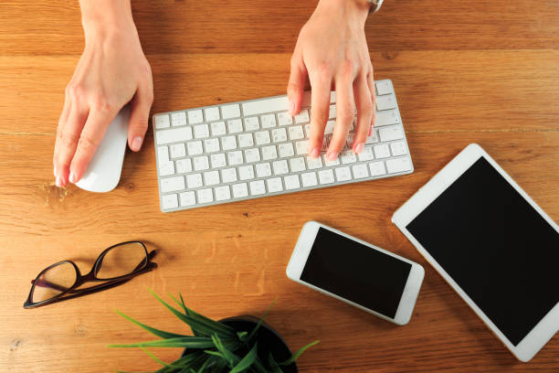 istock Female hands working on wooden work place with modern gadgets  top view - Image 1214634794