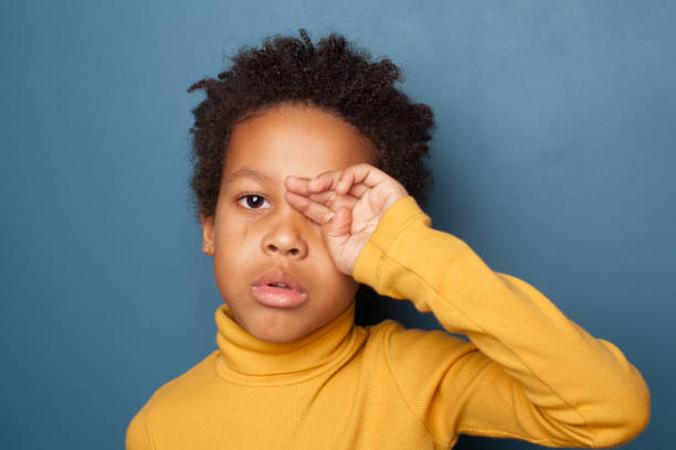 istock Tired unhappy small black child boy crying up on blue background 1214636930