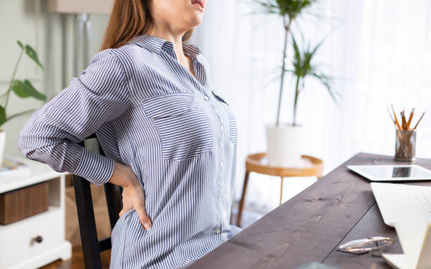 istock Freelancer young woman suffering with back pain 1214637119