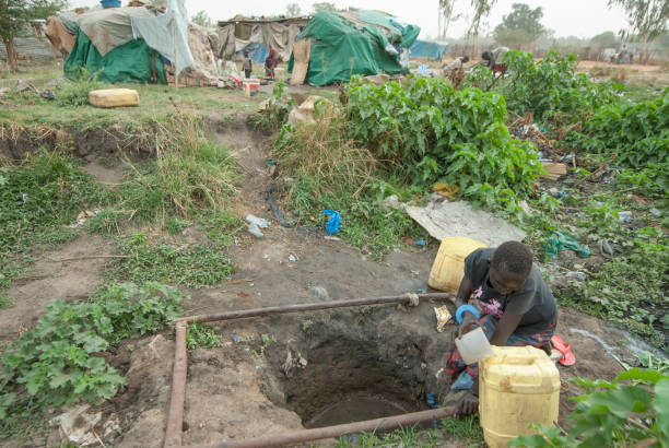 Woman takes potable water in refugee camp, Juba, South Sudan. stock photo