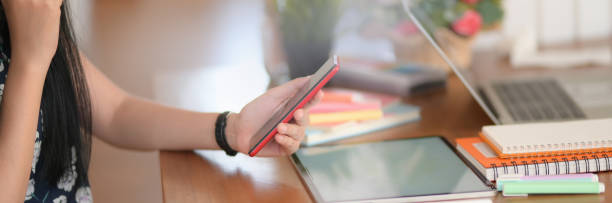 istock Side view of female college student using smartphone to relax from doing homework 1214640521