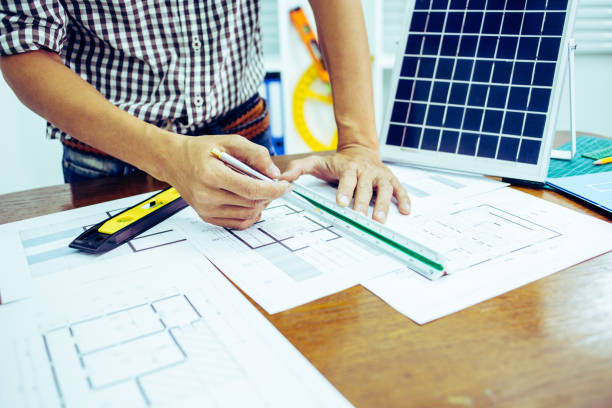 istock Close-up hand of male Architect drawing blueprint on work space in construction site. 1214645032