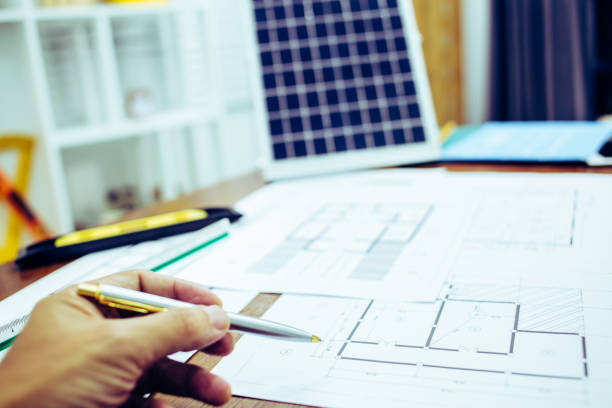istock Close-up hand of male Architect drawing blueprint on work space in construction site. 1214645090