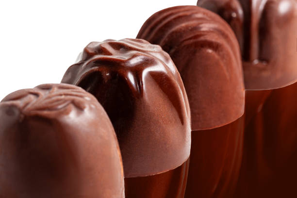 istock Sweet chocolate candy unwrapped in a row on dark background. 1214648092