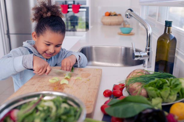 istock Little girl preparing salad, cutting salad leaf (Bok Choy). 1214650878