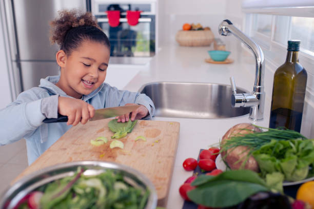 istock Little girl preparing salad, cutting salad leaf (Bok Choy). 1214650997
