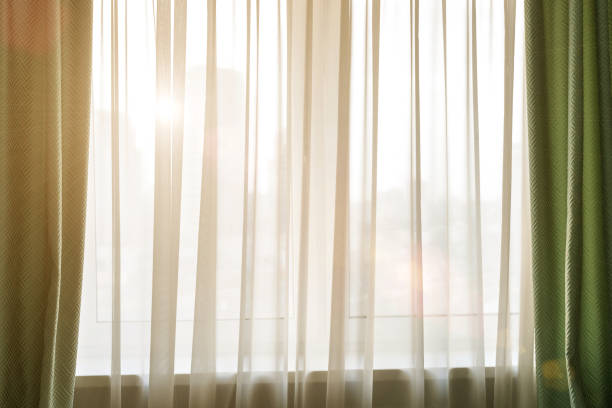 istock sun rays shine into the room through curtain 1214652815