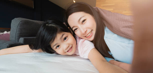 madre e figlia felicità giocare coperta insieme con amore su letto camera da letto sfondo interno - korea child baby asian culture foto e immagini stock