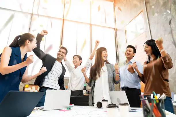 Photo of Multi-ethnic businesspeople cheering with business project successful in meeting room office backgroound