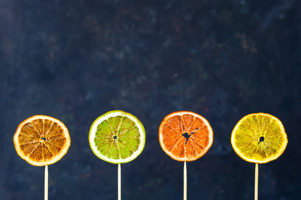 istock Four dried different citrus slices: orange, lemon, lime with wooden sticks, dark background. 1214656540