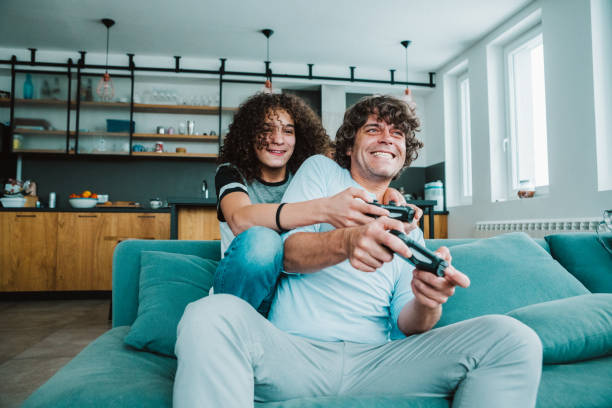 istock Father and son playing digital games at home 1214656615