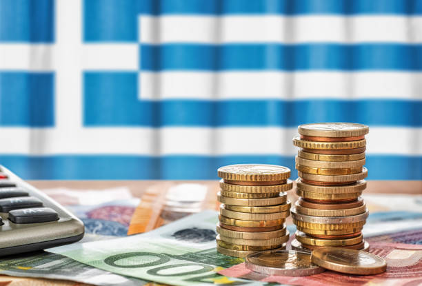 cédulas e moedas do euro em frente à bandeira nacional da grécia - greece crisis finance debt - fotografias e filmes do acervo